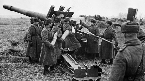 Historische Aufnahme. Soldaten laden schweres Artilleriegeschütz.