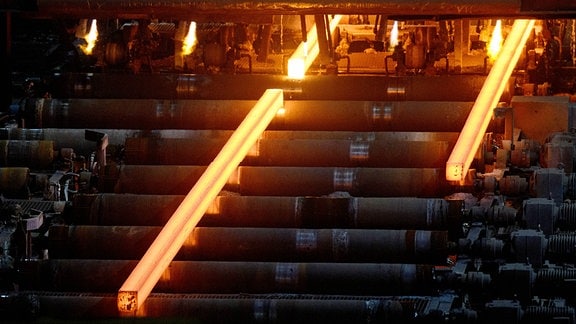 Glühende Stahlknüppel laufen in der Stahlwerkshalle der ESF Elbe-Stahlwerke Feralpi GmbH auf Rollen aus der Stranggussanlage. 