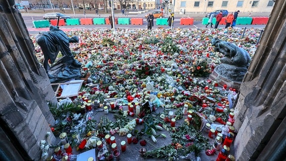 Hunderte Kerzen, Blumen und Plüschtiere finden sich vor der Johanniskirche für die Opfer eines Anschlags.