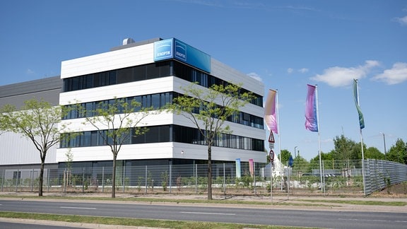 Fahnen mit dem Logo des Technologiekonzerns Jenoptik wehen anlässlich der Eröffnung vor dem neue Hightech-Fab. 
