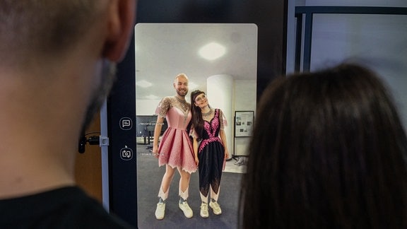 Vanessa Kuhfs und Johannes Häfner vom Scads.AI vor dem "Smart Mirror", der beiden ein schickes Kleid verpasst hat.
