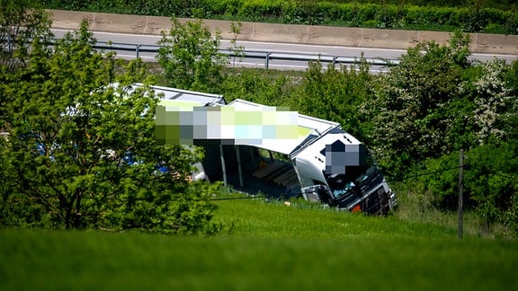Ein Lkw liegt in einem Straßengraben.