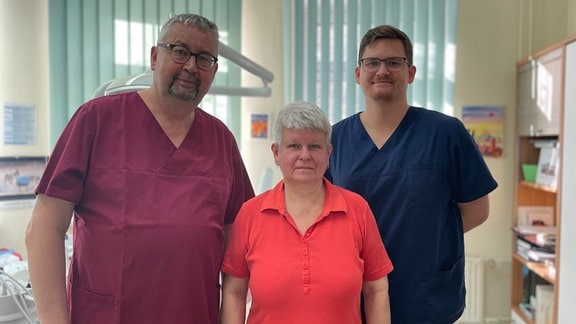 Drei Zahnärzte blicken in die Kamera