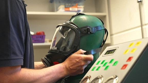 Atemschutzmaske wird auf einen Schaufesterpuppenkopf gezogen